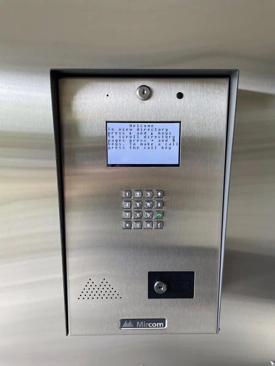 Telephone entry panel with keypad and camera at a building entrance